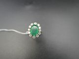 une bague en émeraude et diamant sur une surface noire