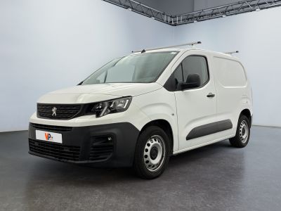 La camionnette blanche est garée dans une grande pièce.