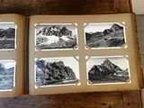 a book with pictures of mountains on it sitting on a table