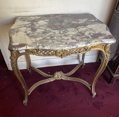 une table au plateau en marbre, surmontée d'un cadre doré
