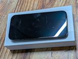 Un iPhone est posé sur une boîte, posée elle-même sur une table en bois.