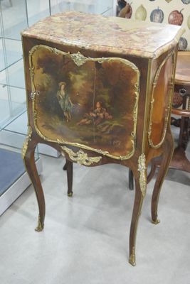 un petit meuble orné d'un tableau, dans une pièce