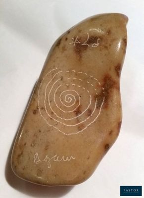 une photo d'une pierre ornée d'un motif en spirale