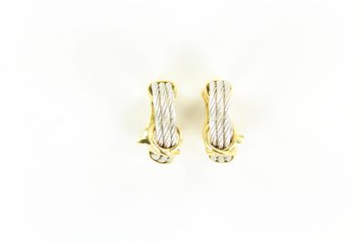 une paire de boucles d'oreilles en or et en argent sur fond blanc