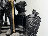 a statue of a knight on a rock with a sword and shield