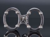 pair of antique silver scissors on a black surface with reflection