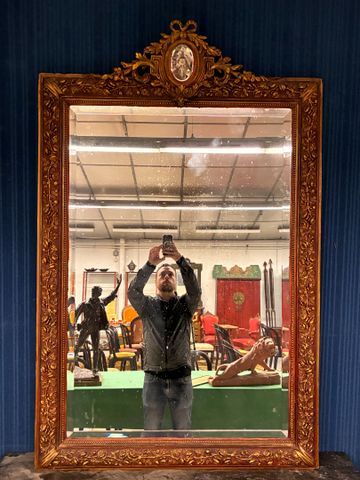 Miroir en bois et stuc doré à décor de guirlandes de roses, médai...