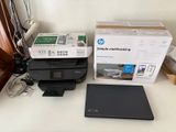 a laptop and printer sitting on a desk next to each other