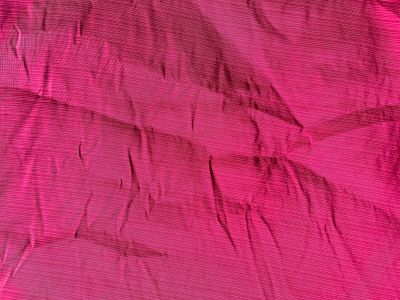 pink fabric with a bow on it laying on top of a bed