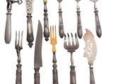 many different types of knives and spoons on this table