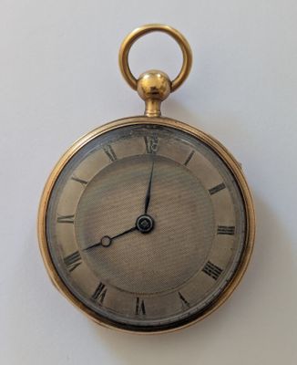 une montre de poche en or avec des chiffres romains sur le cadran