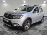 La Dacia argentée est garée sur un sol en carrelage à damier