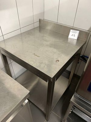 a stainless steel table in the middle of a kitchen