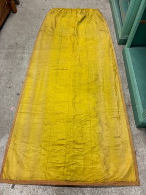 une couverture jaune posée par terre à côté d'une chaise verte