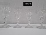 three clear wine glasses are lined up on a white table