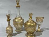 four pieces of gold glass sitting on top of a white table
