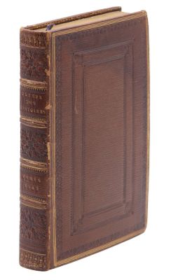 un vieux livre à la couverture brune posé sur une surface blanche