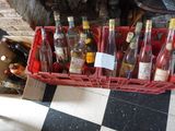 de nombreuses bouteilles de vin dans une caisse rouge posée sur un sol à carreaux