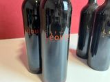 three bottles of red wine sitting on a table