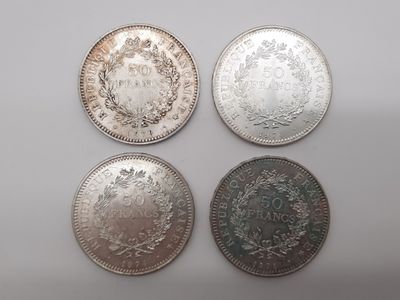quatre types de pièces différents sur une surface blanche