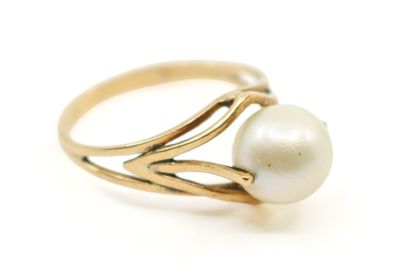 gros plan d'une bague en perle sur une surface blanche