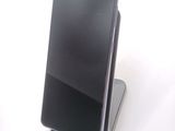 the back of a black cell phone sitting on top of a stand