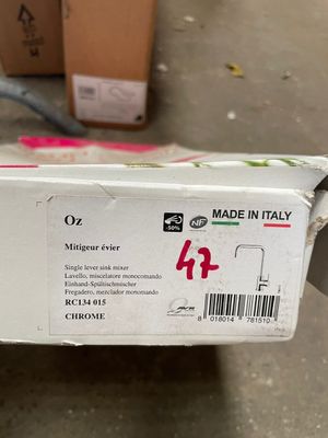 someone is holding up a box of food that is sitting on the floor