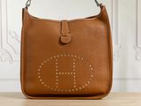 sac à main en cuir marron avec un logo riveté sur le devant