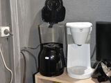 une cafetière et d'autres objets posés sur une étagère dans un coin de la pièce