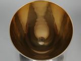 a close up of a metal bowl on a white surface