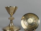 deux bougeoirs en laiton et un plat en argent sur fond gris