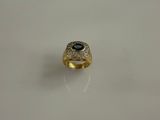Gros plan sur une bague en or ornée d'une pierre bleue