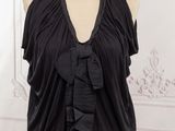 a woman wearing a black top with a large bow on it