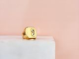 un gros plan d'une bague en or posée sur un bloc de marbre