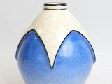 a blue and white vase sitting on a white surface