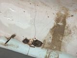 a dirty bathtub with a broken faucet in it