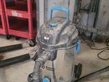 un aspirateur posé sur le sol du garage