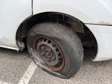 a white truck with a flat tire in a parking lot