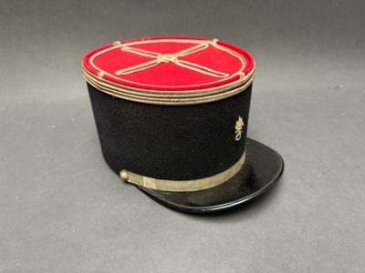 un chapeau noir orné d'un ruban rouge sur le dessus