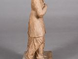 statue of a man in a hat and coat standing on a block