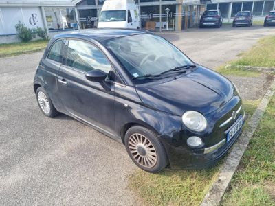 a small black car parked on the side of the road