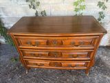 a wooden chest of drawers sitting on top of a sidewalk