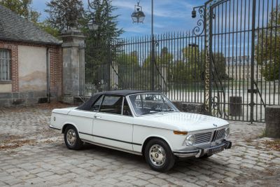 une voiture blanche garée devant un portail