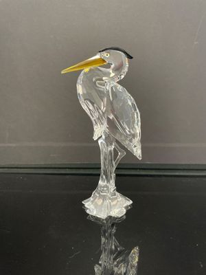 un oiseau en verre posé sur une table en verre