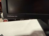 a computer monitor sitting on top of a desk next to a keyboard