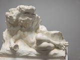 a statue of a woman sitting on a rock