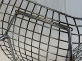 a metal wire chair that is sitting on a white surface
