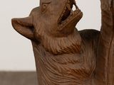 a wooden statue of a cat with its mouth open