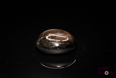 an image of a black and silver object on a black surface