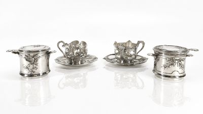 trois tasses à thé et soucoupes en argent sont posées sur une surface blanche